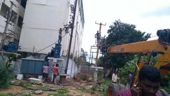 Crane setting distribution poles on an 11 KV line route
