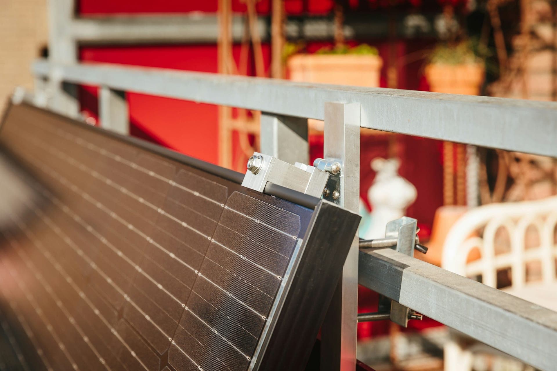 A photovoltaic module clamped to an aluminium mounting rail, showing the fixing detail