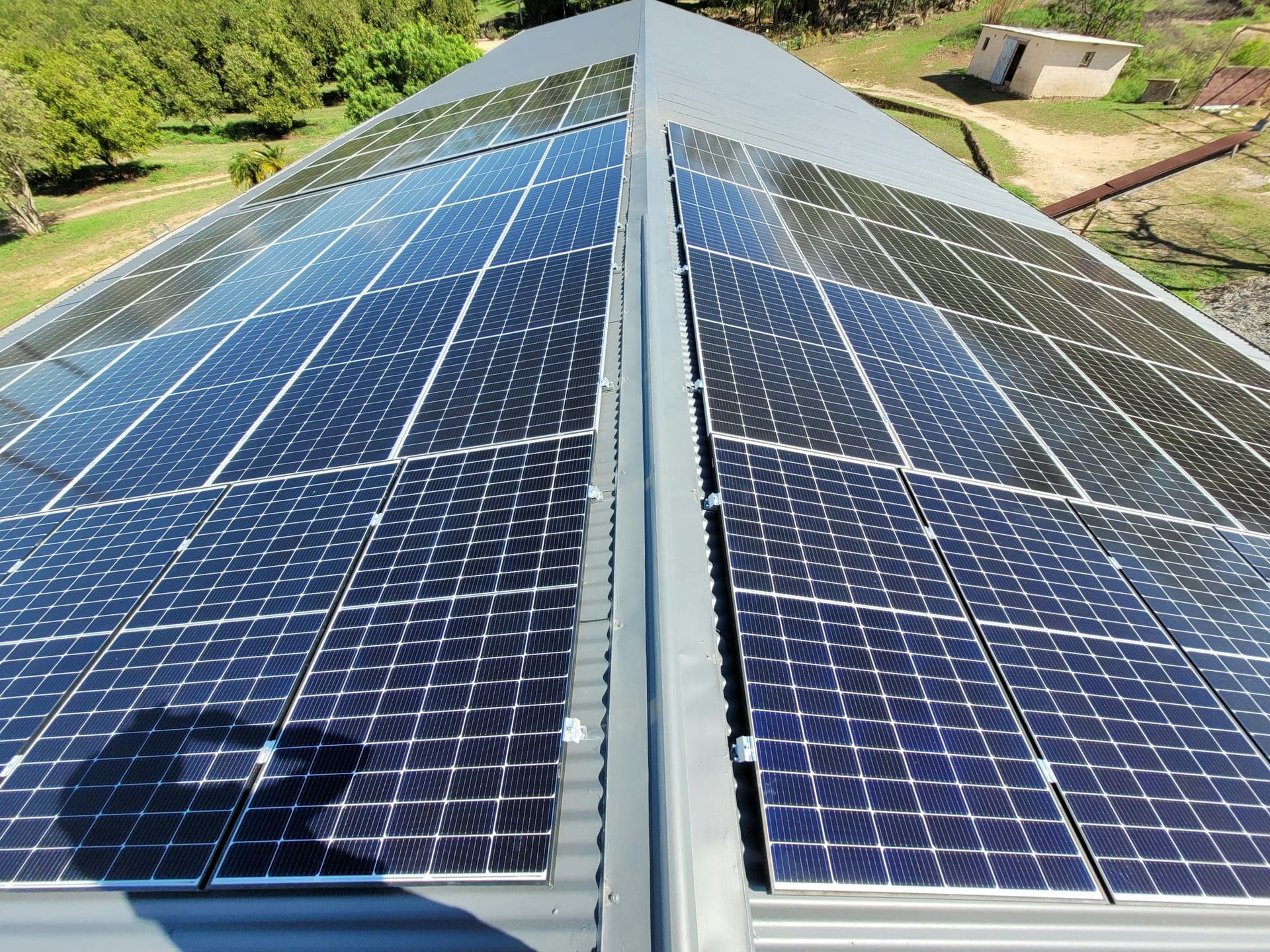 Photovoltaic modules mounted in two rows along the ridge of a corrugated metal roof