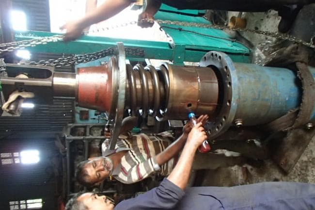 Technician working on a stripped propulsion shaft assembly